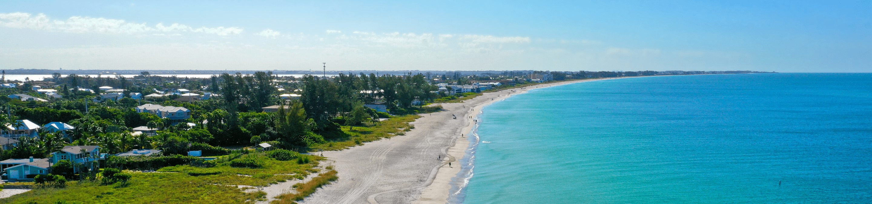 Aerial view from drone looking at the northern part of the beach on Anna Maria Island on a bright sunny day with the gulf of Mexico on the right