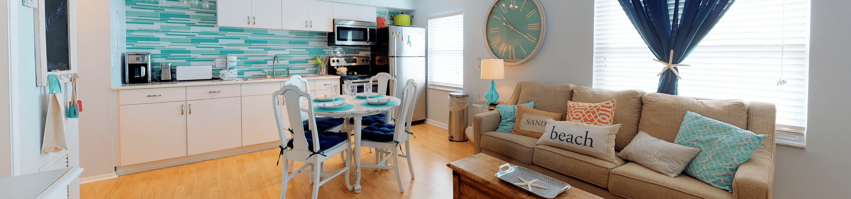 One of our beautiful 1 bedroom rentals anna maria island open area of living room and kitchen featuring a small round dining table for four in the middle located on Anna Maria Island