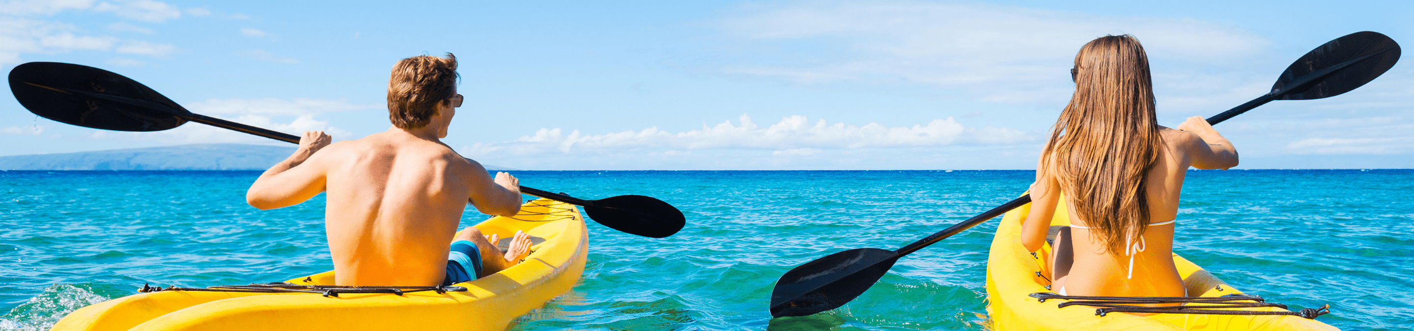 a man and woman on separate kayaks paddle out to the open waters of the Gulf of Mexico