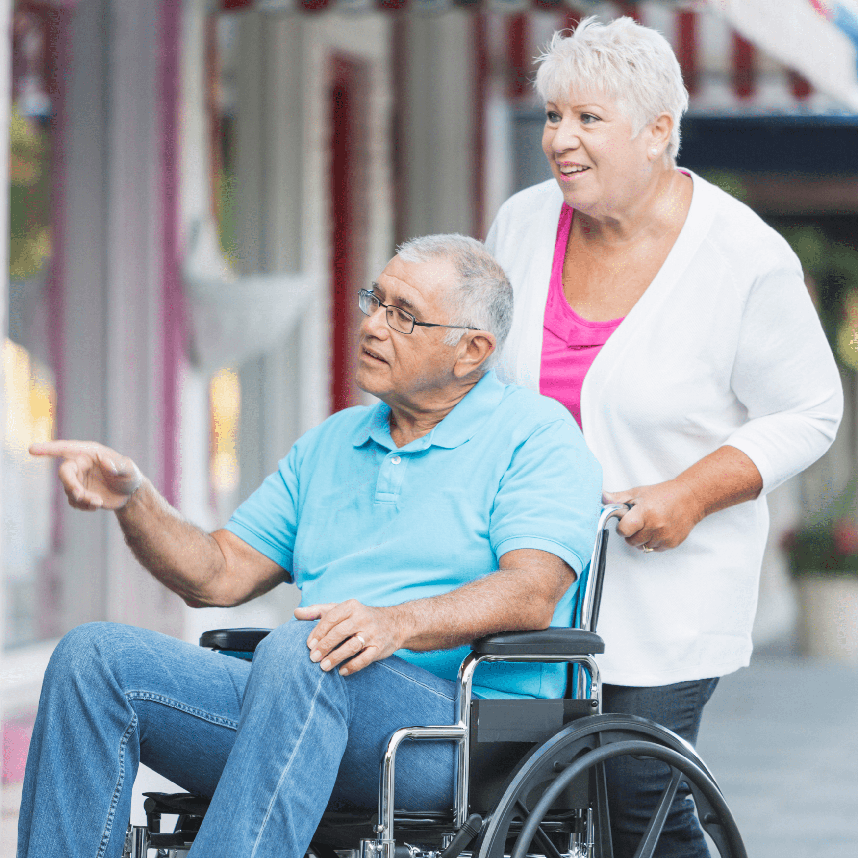 Woman pushing man in wheelchair