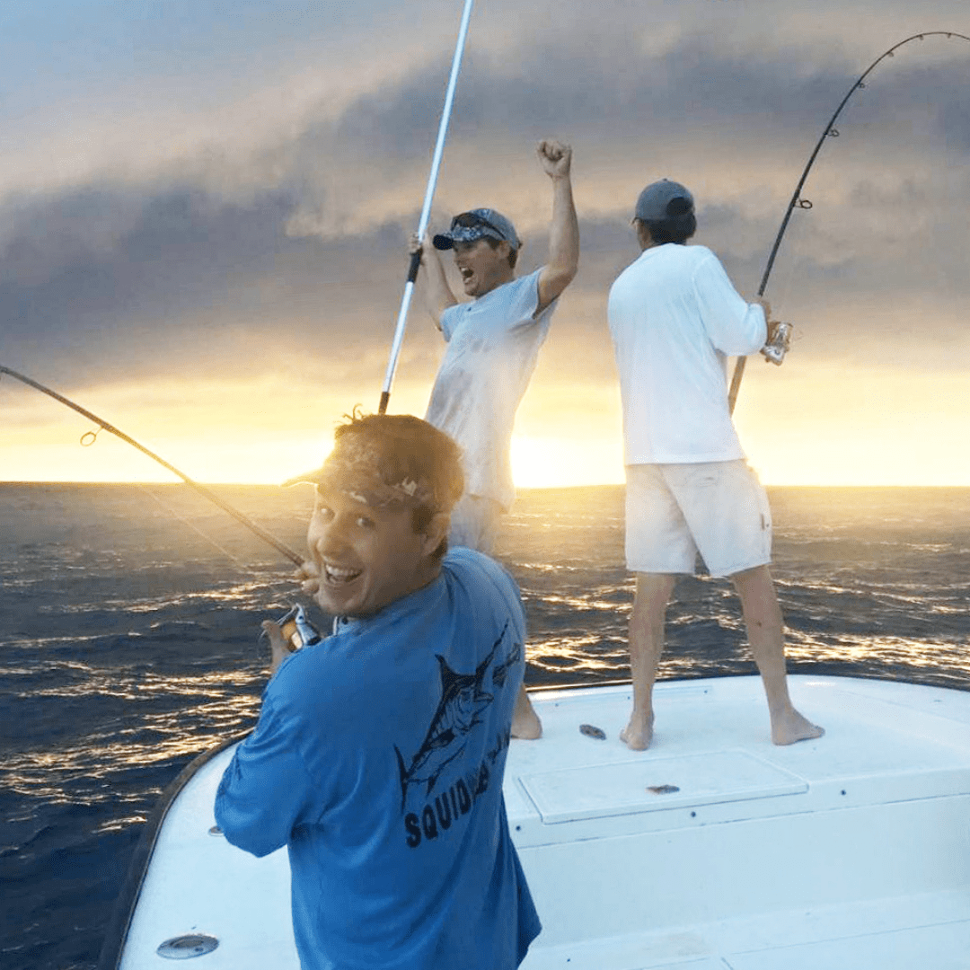 Three men standing on a boat deep sea fishing off the coast of Anna Maria Island.