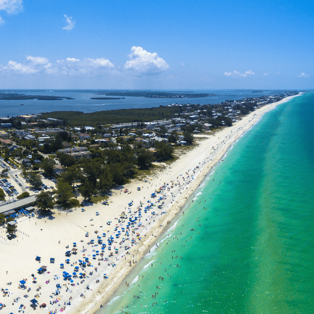 Aerial shot of Manatee public beach on Anna Maria Island. Gulf of Mexico and Sarasota bay. People on the beach.
