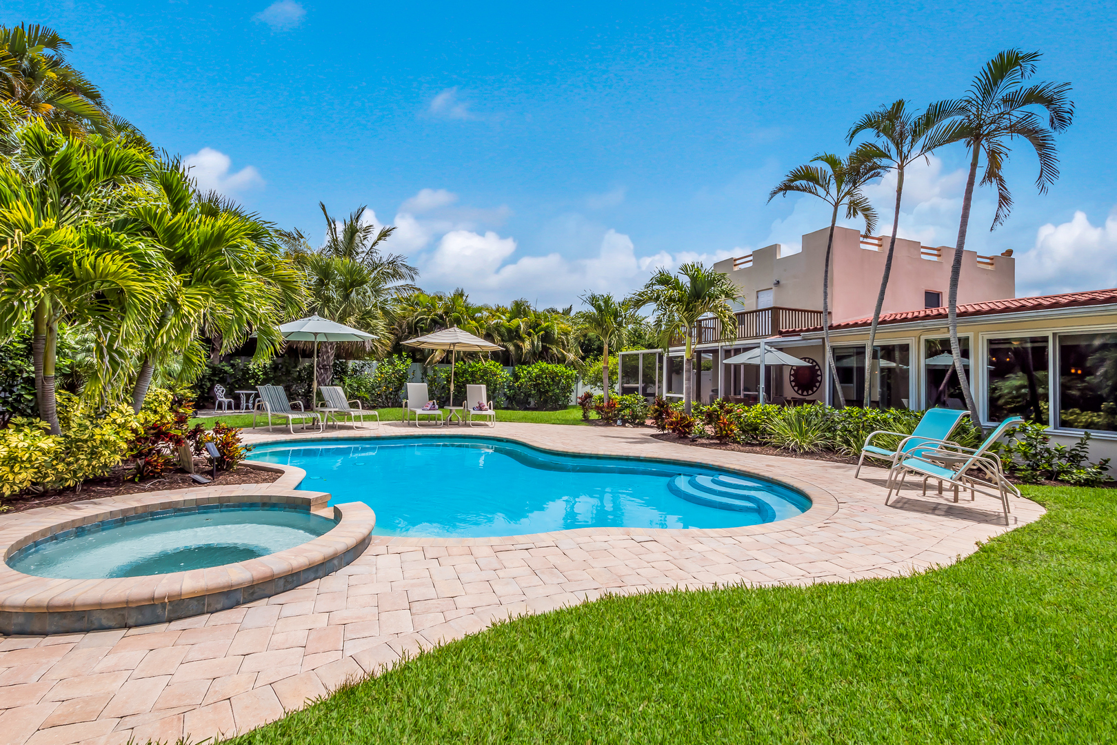 The large tropical back yard and lagoon style pool and spa at Glory Days, a vacation rental by Anna Maria Life Vacation Rentals
